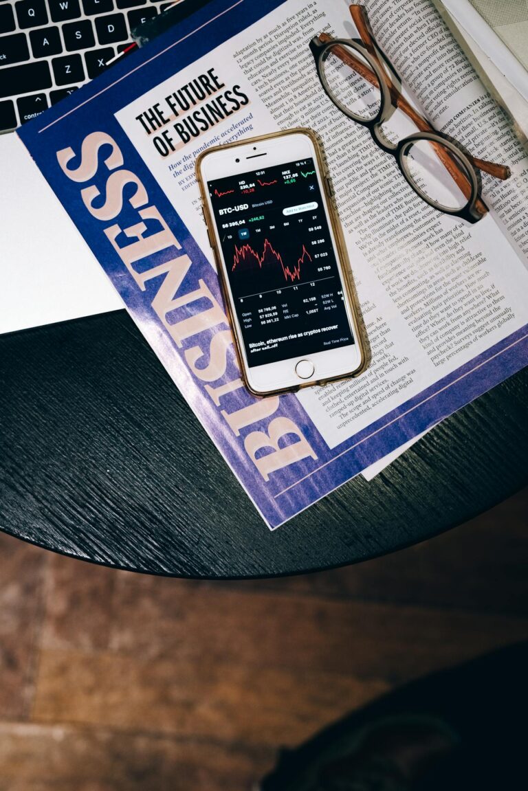 Smartphone displaying stock data on a magazine titled 'The Future of Business'.